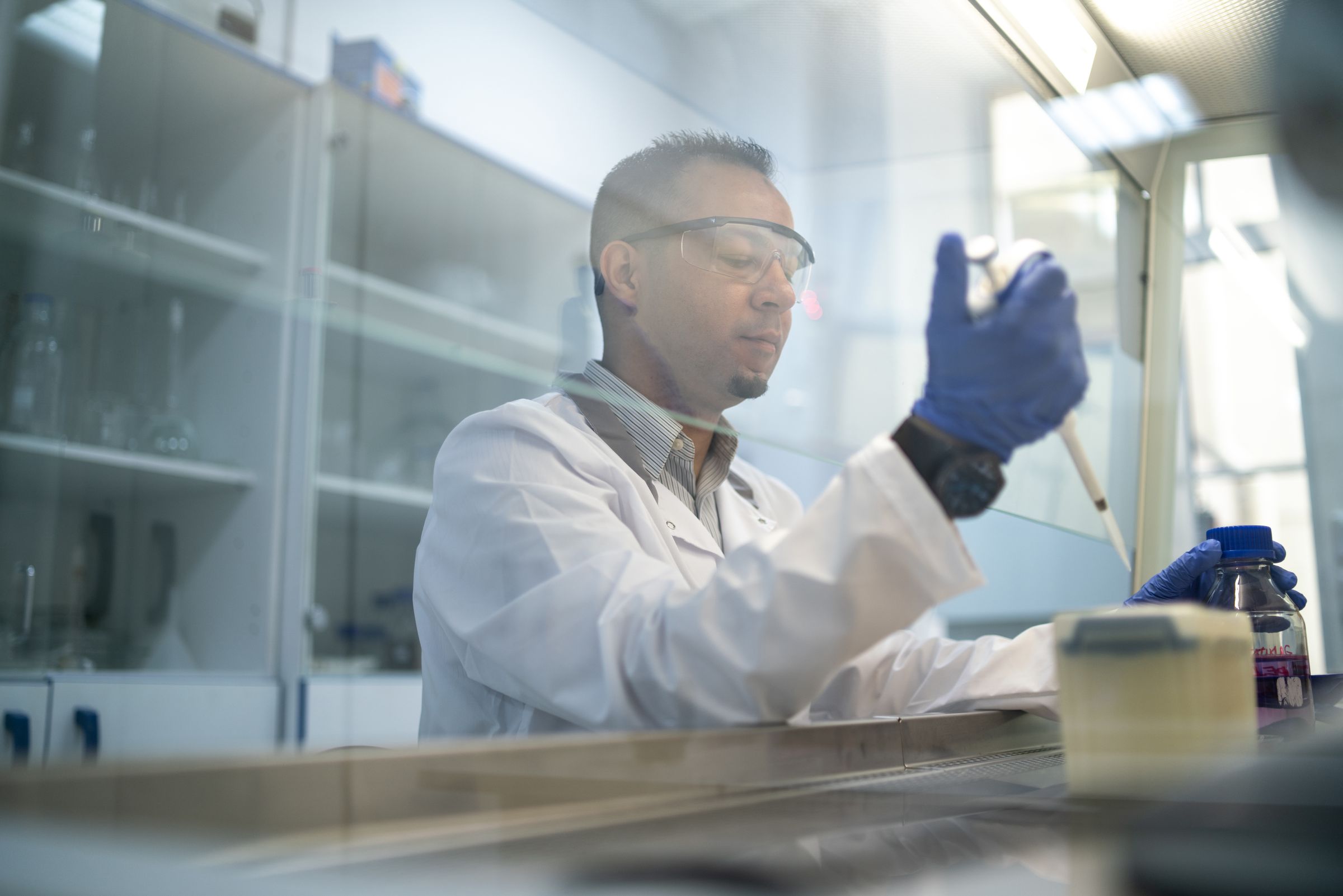 A scientist in protective glasses conducting laboratory research